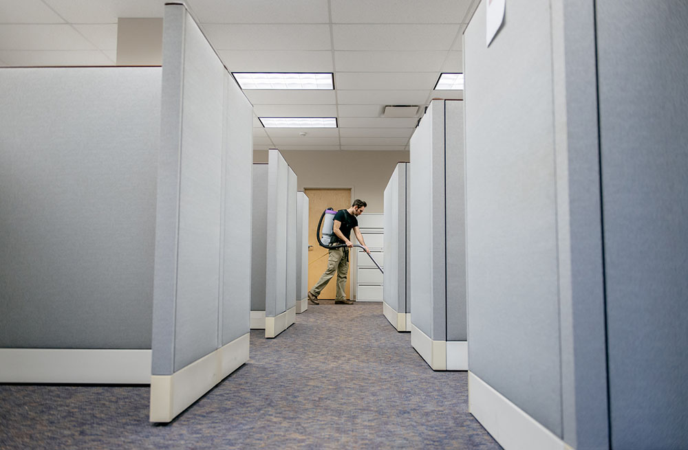 commercial cleaner vacuuming cubicles